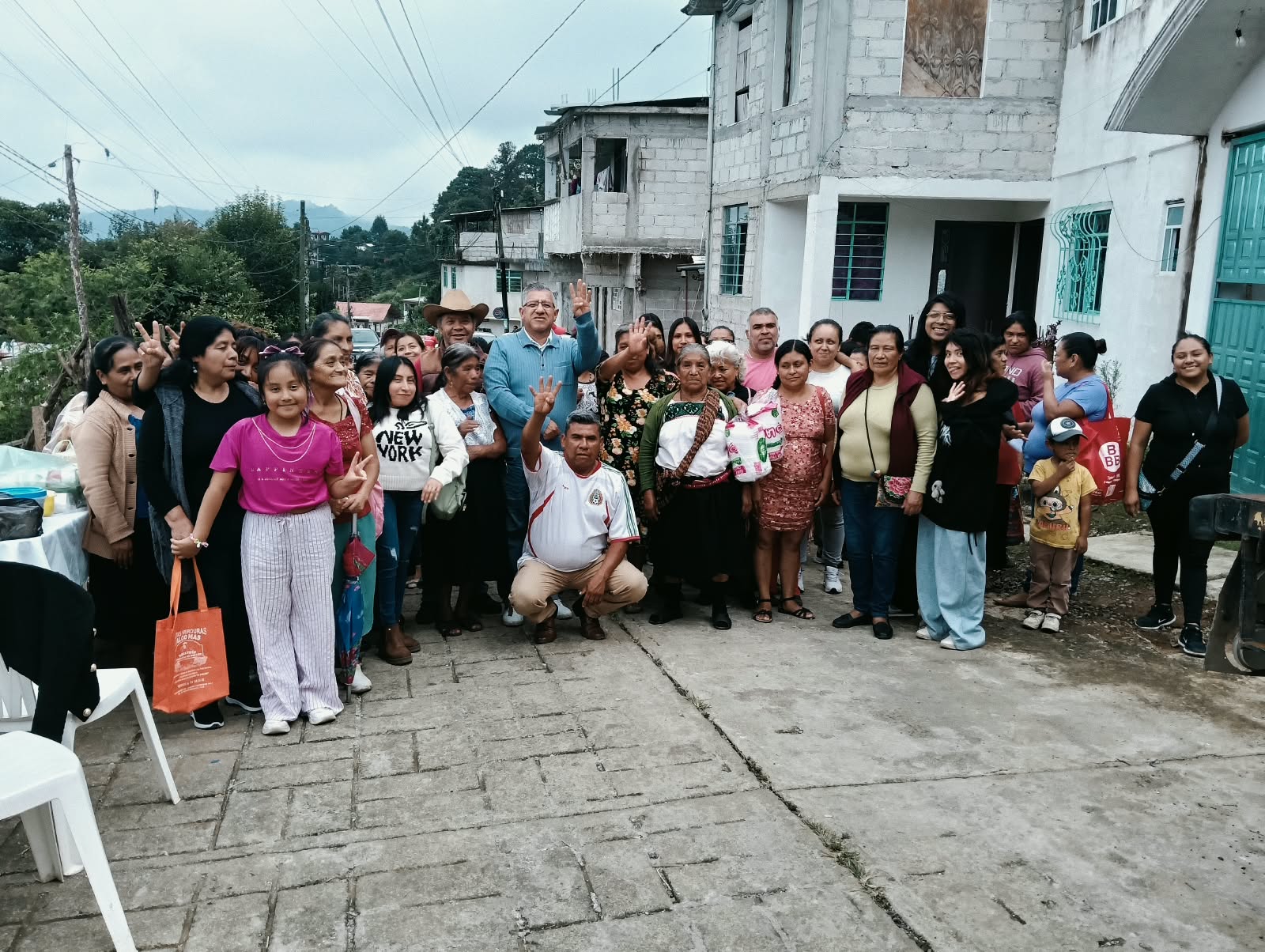 Vecinas y vecinos se reúnen en una calle de Huauchinango para un encuentro comunitario.